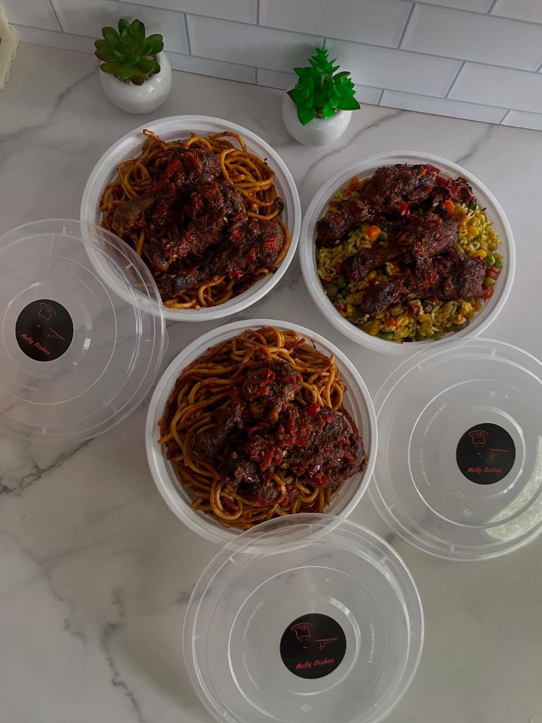 Melly Dishes takeout containers with jollof and spaghetti